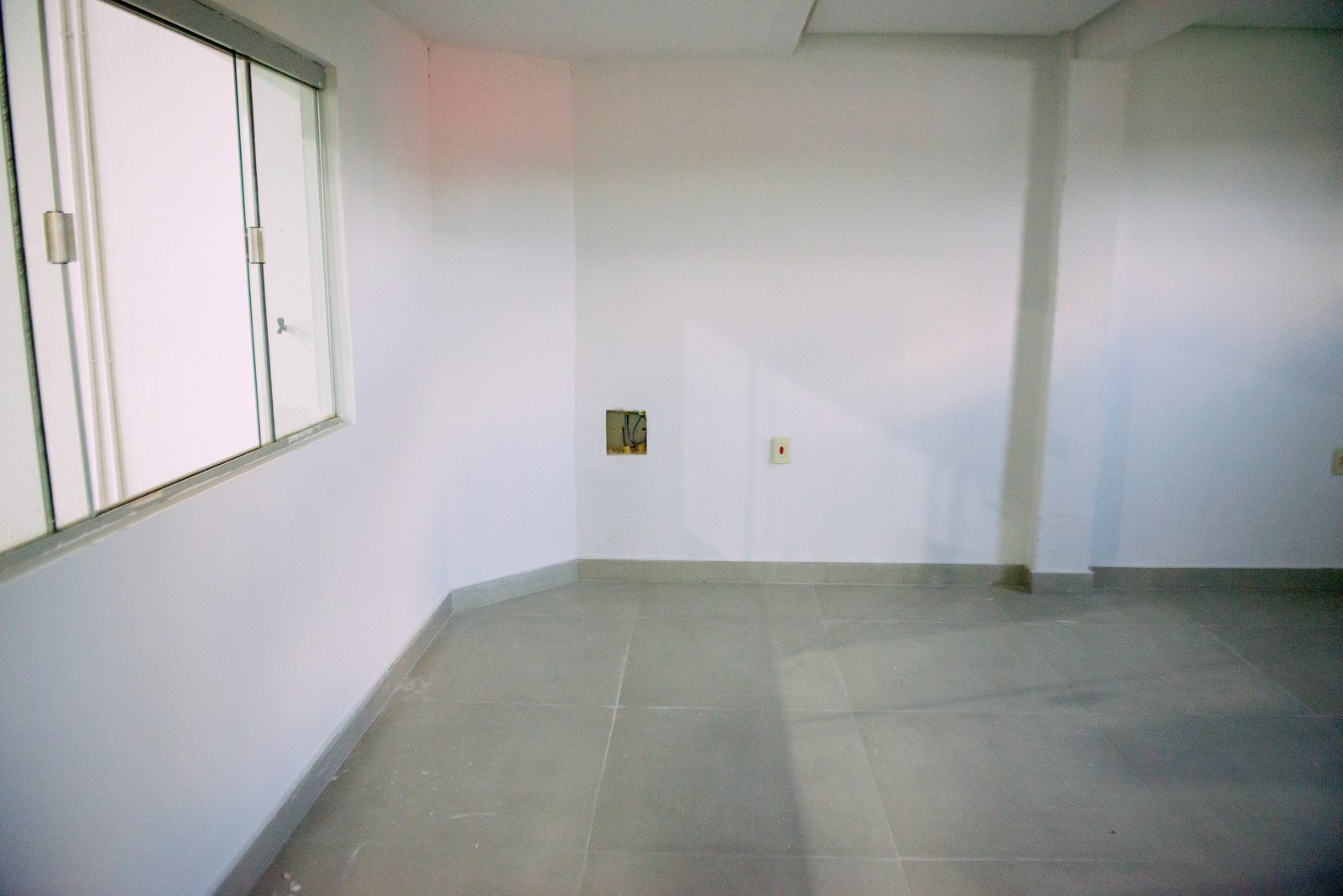 Sala do térreo com janela de vidro para o galpão