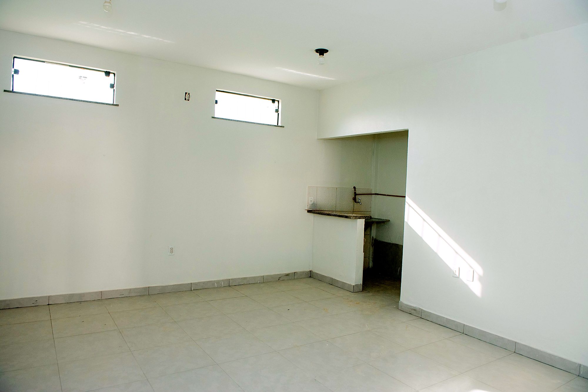 Sala com janelas altas e copa integrada