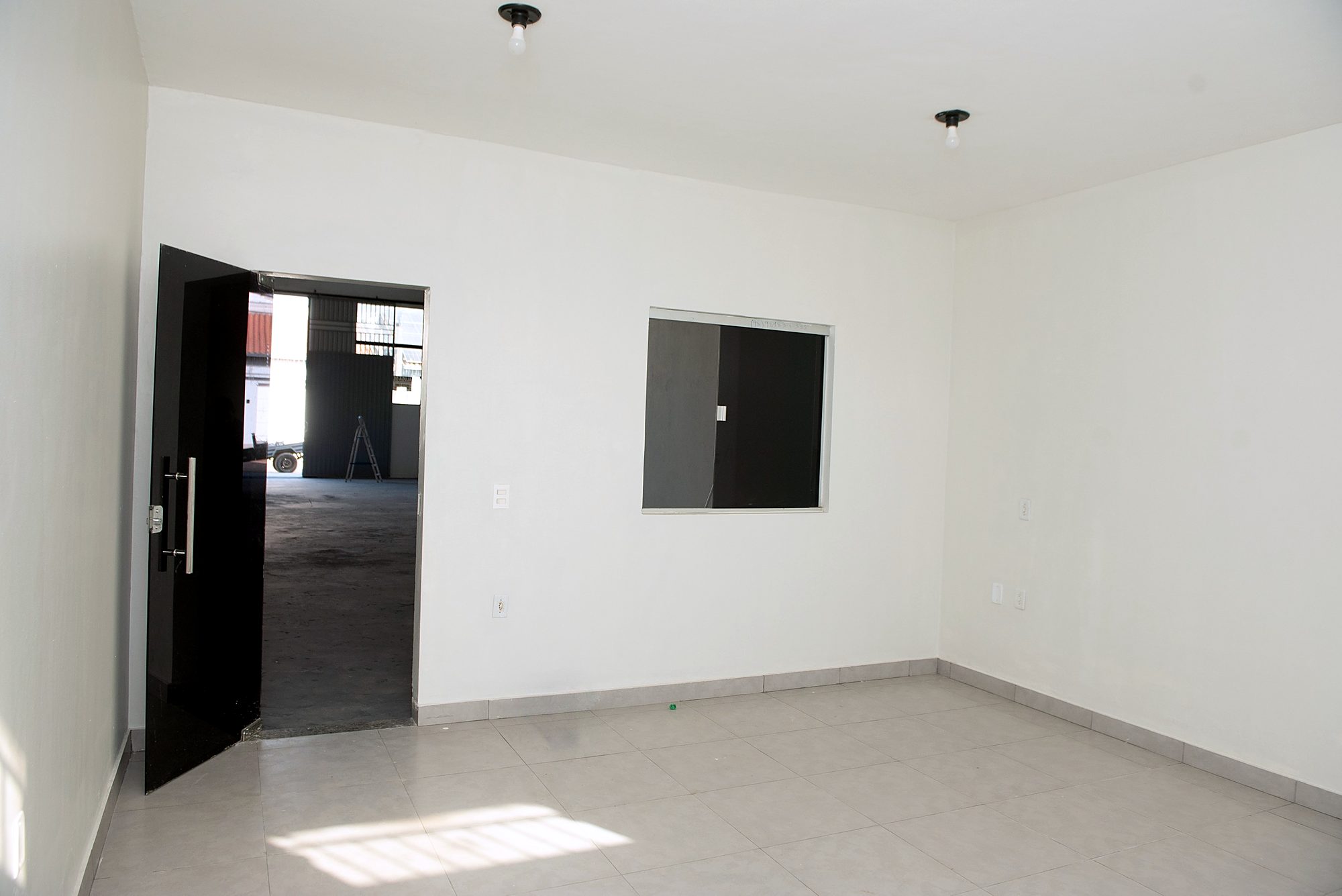 Sala do térreo com porta de vidro e visor para a área operacional